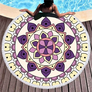 Mandala pattern round beach towel with white tassels on pool wood deck