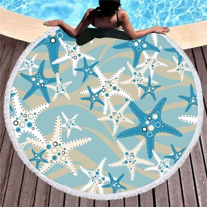 Thick circular beach towel with blue starfish print and white fringe tassels for vacation