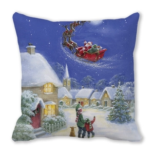 Detalle de funda de cojín navideño con Papá Noel volando sobre un pueblo nevado