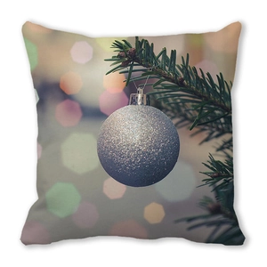Close-up of Christmas cushion cover showing silver ornament print on peach skin fabric