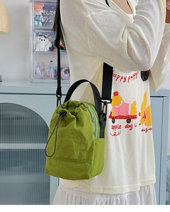 Bolso bandolera de nailon verde hierba que muestra el estilo cubo y detalles de cordón