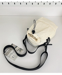 Detalle del bolso bandolera ligero blanco roto con cordón negro y correa ajustable