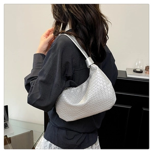 Detailed close-up of woven metallic silver hobo bag with sleek mesh texture on shoulder
