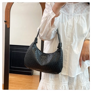 Detail shot of the black woven leather texture and hobo shape of the shoulder tote bag