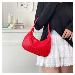 Detail of red woven hobo bag with wide shoulder strap and glossy checkered texture