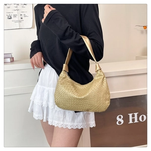 Close-up of golden embossed woven texture on a soft PU leather hobo shoulder bag