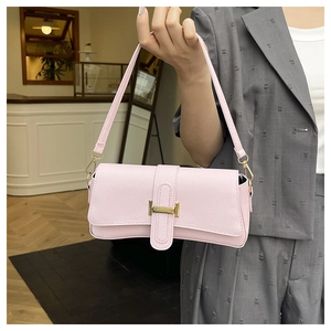 Detail of light pink shoulder bag with gold H-buckle and textured leather finish