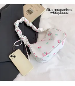 Floral canvas bag size comparison with smartphone showing shoulder strap details