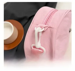 Close-up of pink nylon coin purse with plastic hook and smooth zipper texture