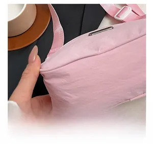 Close-up of pink nylon crossbody bag showing precise stitching and durable fabric texture