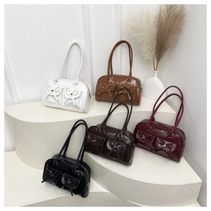 Detailed view of multiple vintage-style shoulder bags with bow ties in various colors
