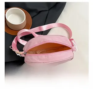 Pink nylon crossbody bag interior detail showing main compartment storage and zipper