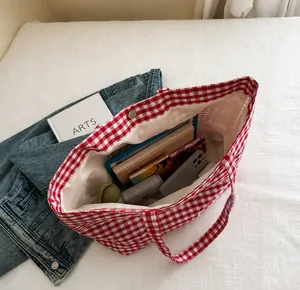 Inside view of red checkered canvas tote showing large capacity and magnetic closure