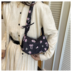 Close-up of black crescent shoulder bag featuring pink rose and bow prints