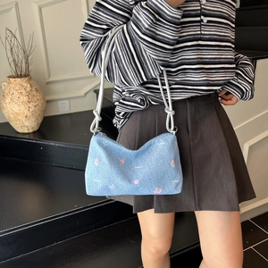 Light blue denim tote bag with pink floral embroidery and thick white rope shoulder strap