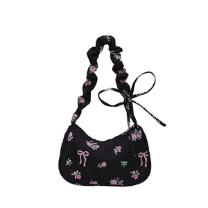 Black nylon underarm bag with pink rose and bow prints featuring ruffled strap