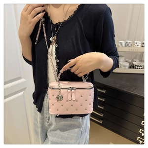 Detail of pink quilted box bag with sparkling rhinestones and silver rose charm