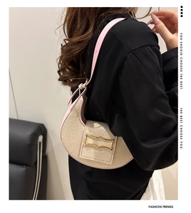 Détail du sac hobo en paille beige avec bordure en cuir rose et boucle en métal doré