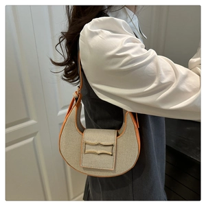 Détail du sac demi-lune en toile avec bordure en cuir orange et boucle dorée élégante