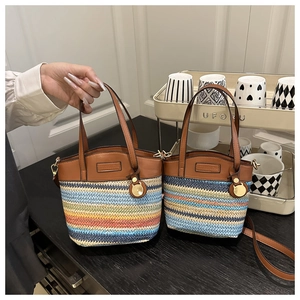 Détail de sacs seaux tissés colorés en deux tailles avec bordure en cuir marron et breloques