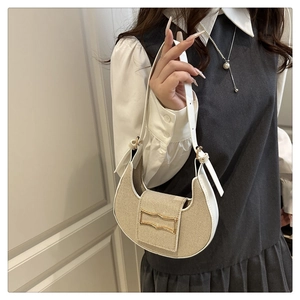 Detail of crescent shoulder bag with straw texture stitching and golden metal buckle