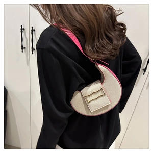 Détail du sac demi-lune tressé beige avec bordure en cuir rose et boucle dorée