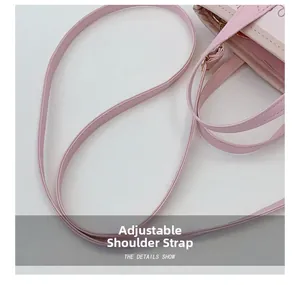 Detail view of pink leather bag showing adjustable shoulder strap and stitching craftsmanship