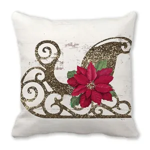 Detail of Christmas pillowcase with golden sleigh and red poinsettia on white wood texture