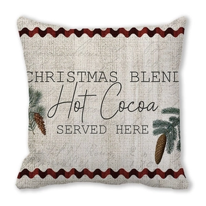 Detalle de funda de cojín navideño con reno geométrico y texto de chocolate caliente