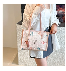 Detailed close-up of pink tote bag with elegant floral embroidery and tassel charm