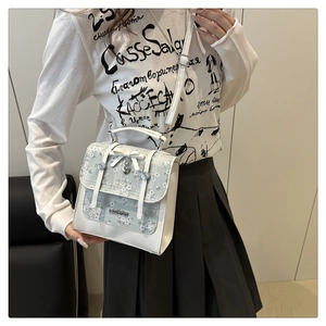 Chic floral crossbody bag with bow and heart charm worn by model in casual setting