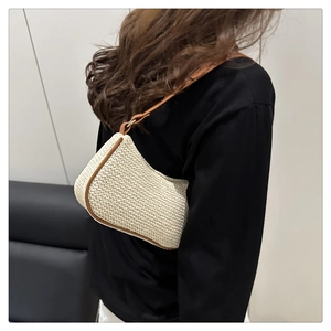Vista laterale dettagliata di una borsa sottobraccio intrecciata beige con finiture in pelle