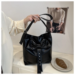Détail du sac fourre-tout noir brillant avec grand nœud et strass argentés étincelants