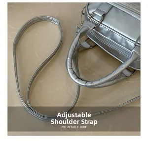 Detail showing adjustable shoulder strap and silver metallic surface of the handbag