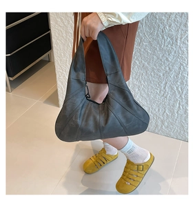 Detailed view of a dark grey crescent hobo bag with unique radial stitched panels