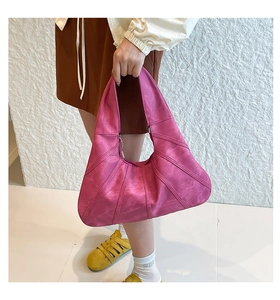 Close-up of rose pink shoulder bag with unique geometric stitching and matte faux leather
