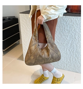 Detailed view of vintage brown moon bag with stitching on wax texture leather