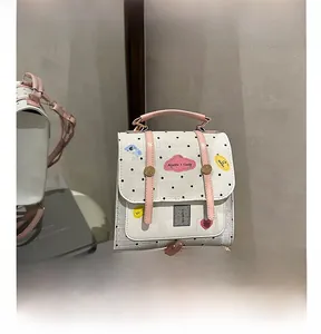 Close-up of white polka dot backpack with pink straps and cute cartoon sticker details
