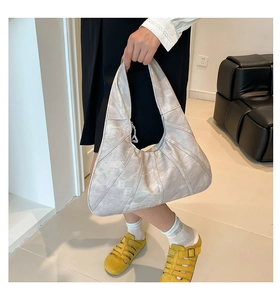 Detail of silver-grey hobo bag featuring paneled leather craftsmanship and marble texture