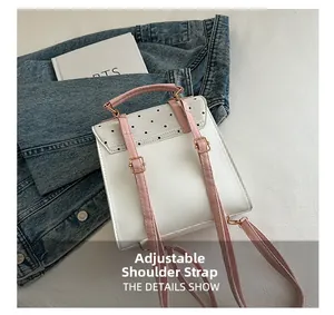 Detail showing adjustable pink faux leather shoulder strap of the polka dot backpack