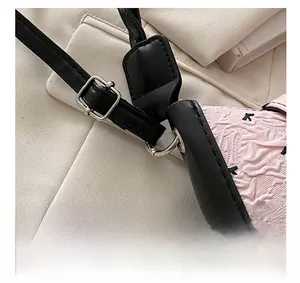 Detail of pink embossed texture and black bow pattern with adjustable silver metal buckle