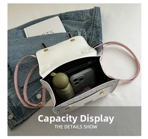 Internal capacity display of a small white crossbody bag holding a phone and umbrella