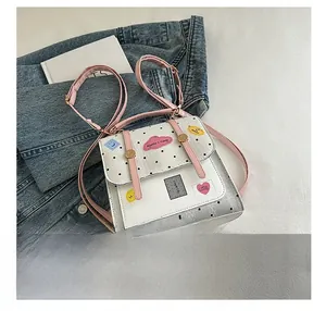 Detailed close-up of a polka dot patterned backpack with cute cloud patches and charms