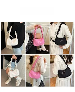 Detail view of nylon underarm bags in white, pink, and black colors with bow embroidery