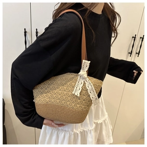 Detail of summer woven bucket bag with lace bow and bicolor straw texture craftsmanship