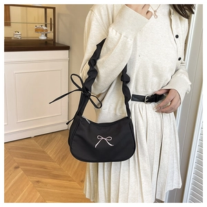 Detail of black shoulder bag with pink bow embroidery and pleated drawstring strap