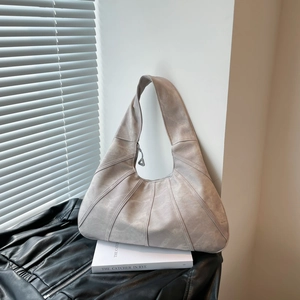 Minimalist large tote bag in greyish brown with geometric stitching on a book