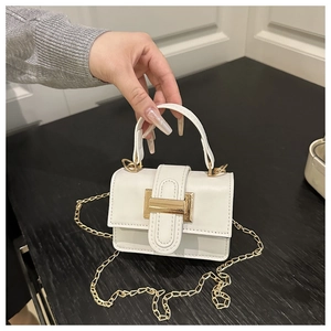 Détail d'un mini sac bandoulière blanc avec boucle métallique dorée et chaîne