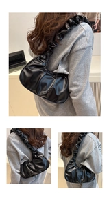 Detail shot of the black pleated cloud bag showing soft PU material and gathered shoulder strap