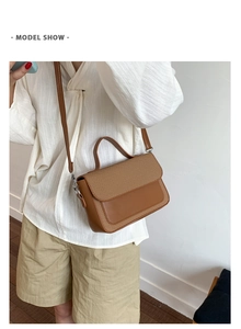Detailed view of brown crossbody bag featuring woven texture and silver hardware